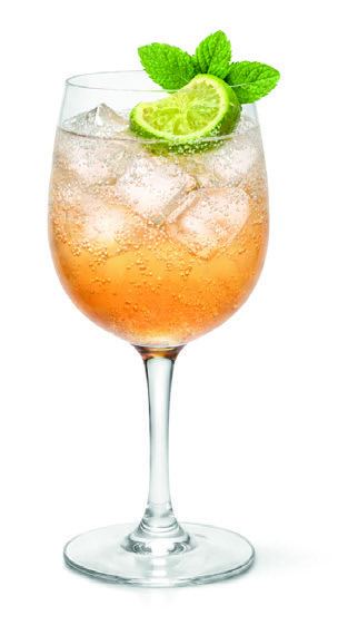 A wine glass of kombucha spritz with ice, lime and mint.
